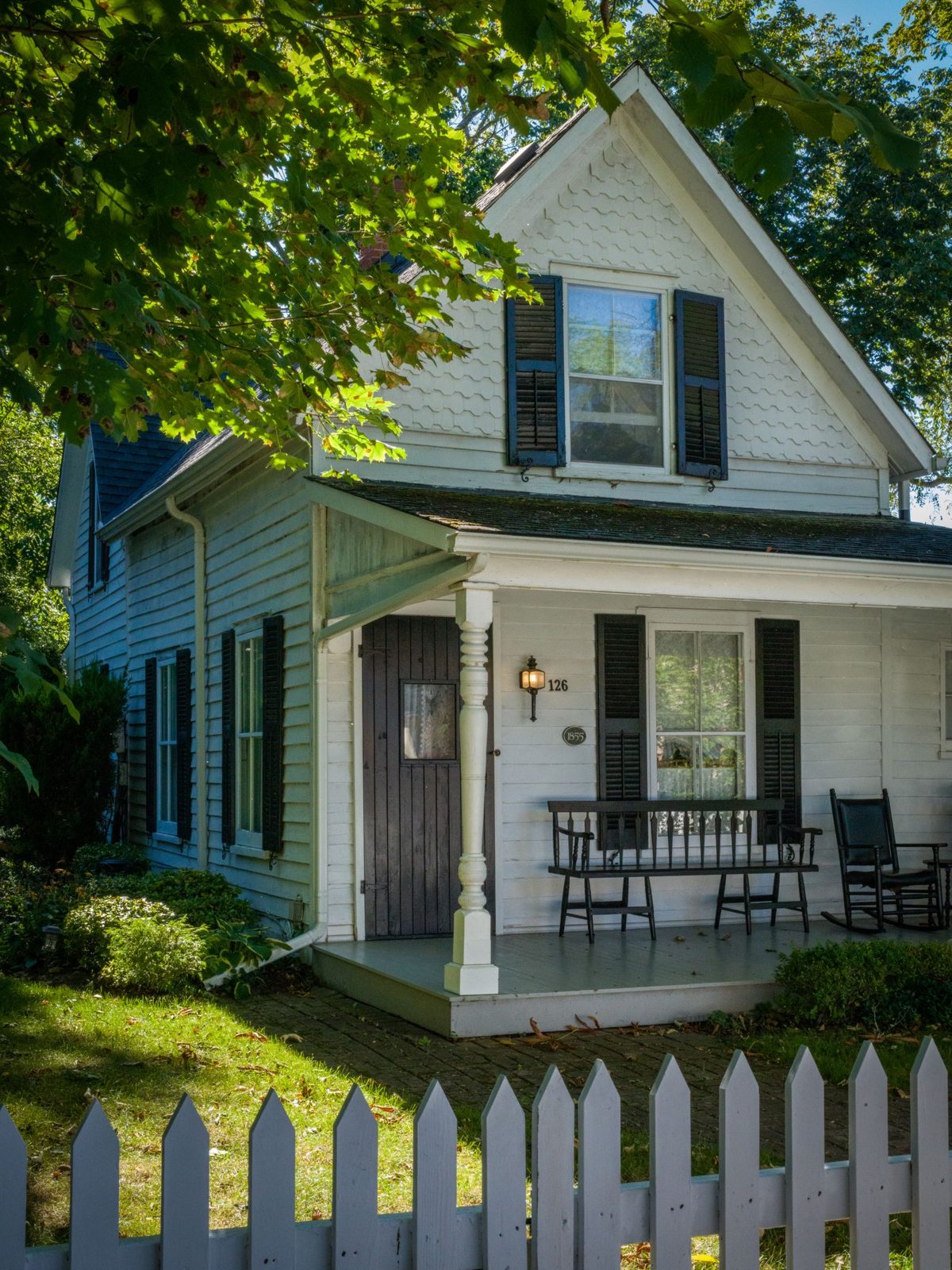 Charming white house with picket fence. Photo by Ali Soheil